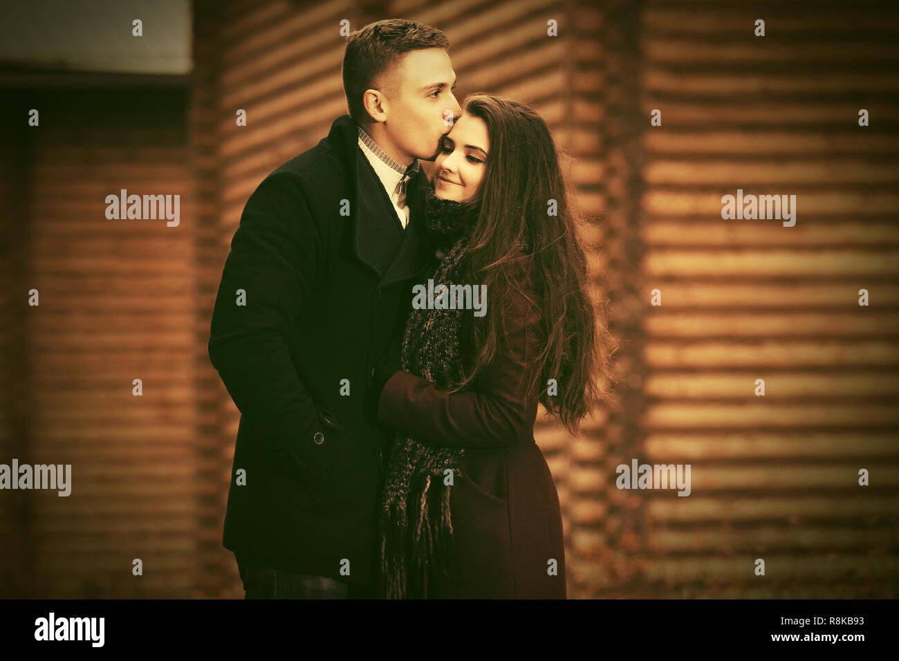 Felice moda giovane coppia in amore kissing outdoor elegante l uomo e la donna nel classico cappotti Foto Stock