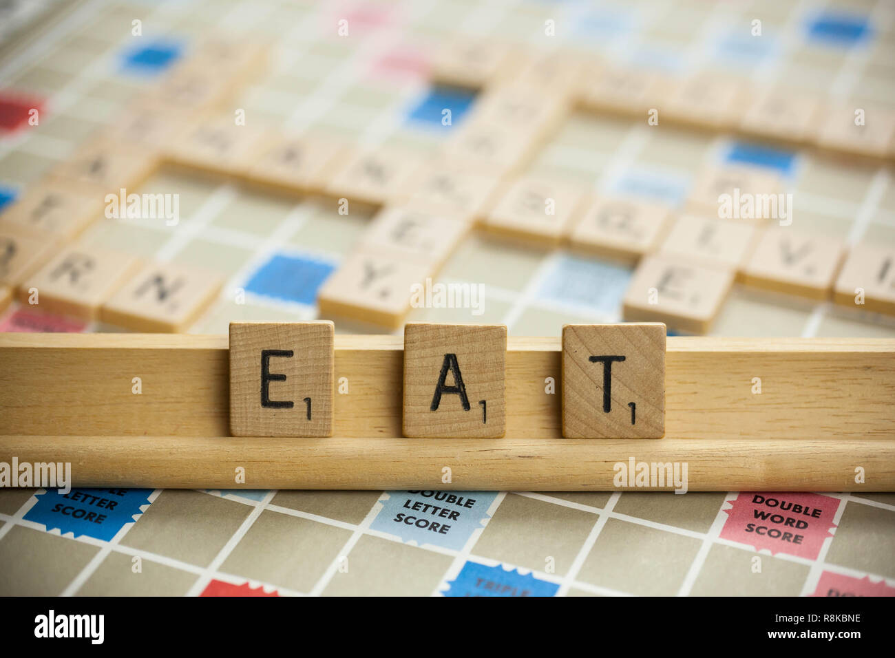 WOODBRIDGE, NEW JERSEY - 9 Novembre 2018: piastrelle Scrabble scrivi la parola mangiare su un vintage scheda di gioco Foto Stock
