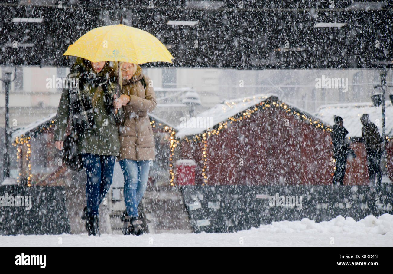 A Belgrado, in Serbia - Dicembre 15, 2018: due giovani donne camminare sotto ombrellone in forte nevicata in strada di città con Natale decorati sorge in lui ba Foto Stock