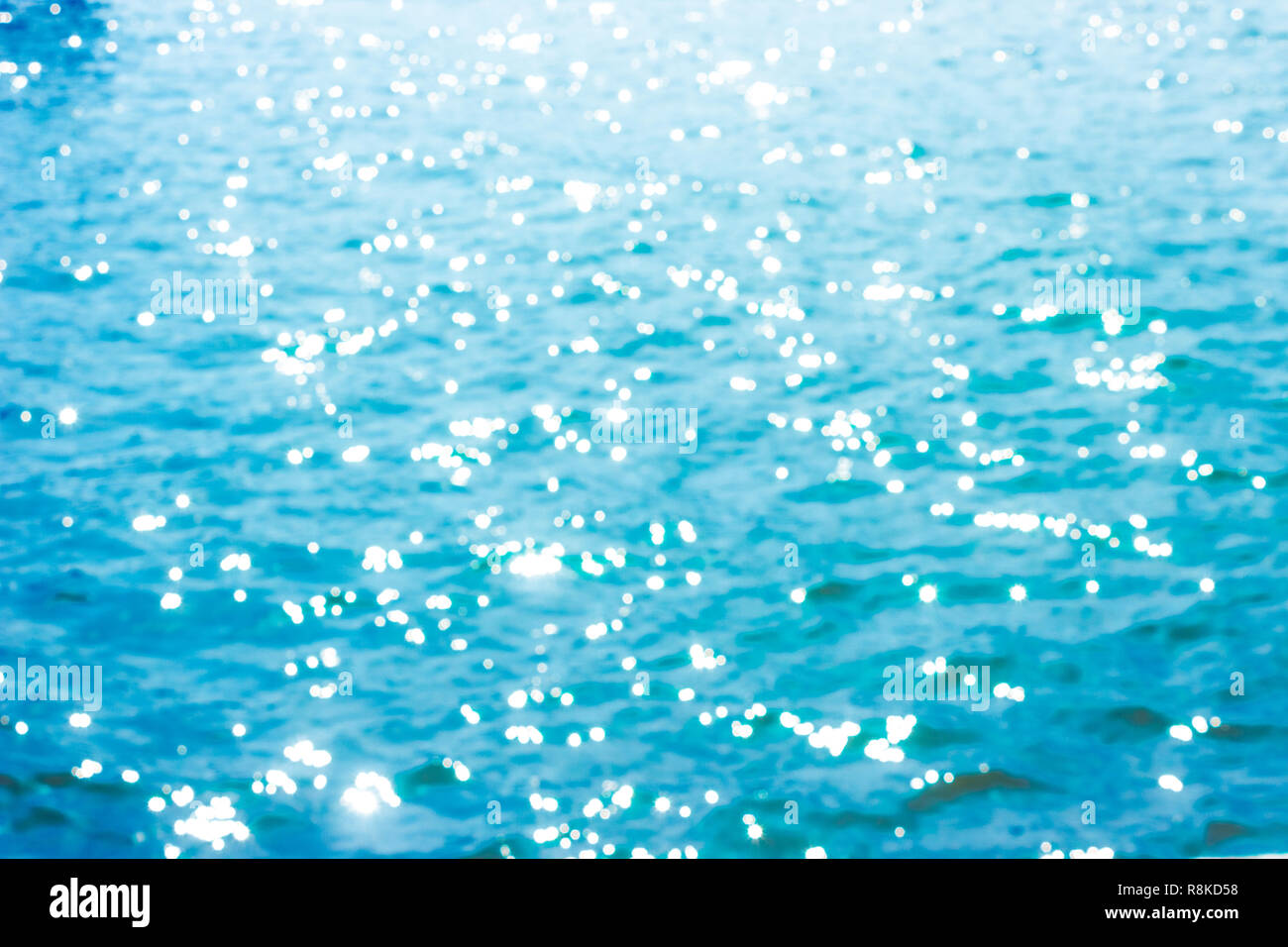 Abstract bokeh di fondo alla luce del sole lo sfondo con estate mare blu. Foto Stock