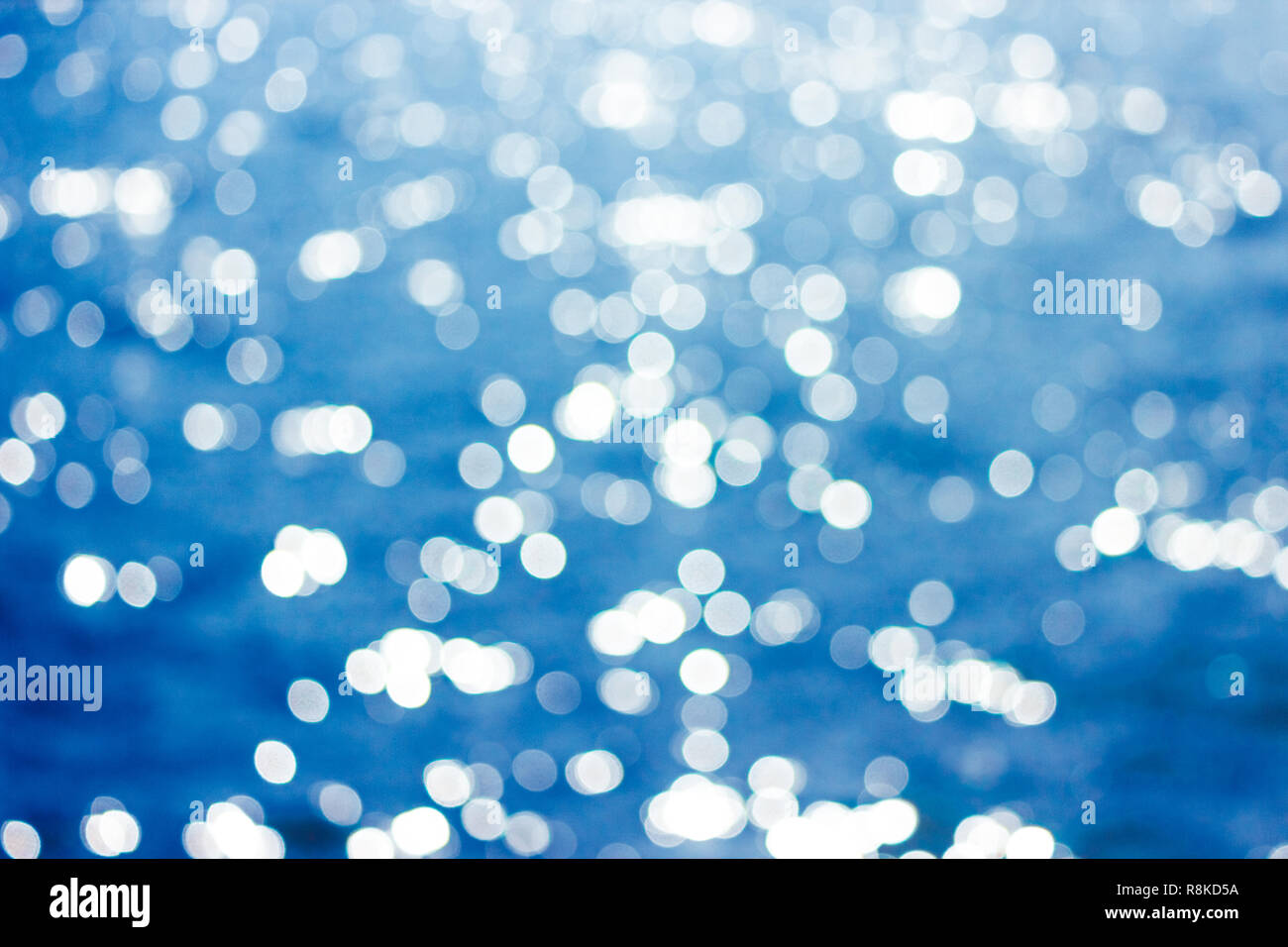 Abstract bokeh di fondo alla luce del sole lo sfondo con estate mare blu. Foto Stock