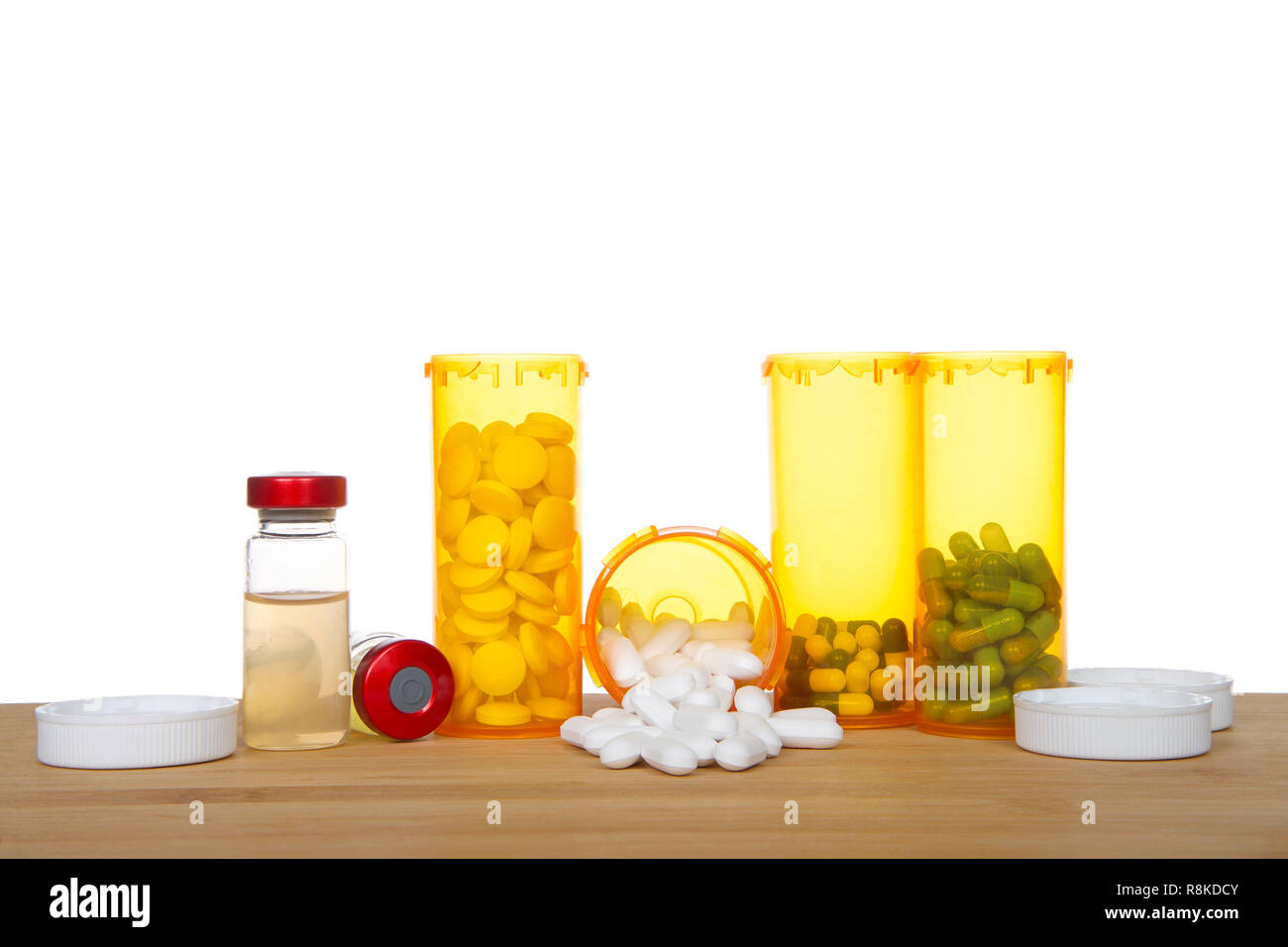 Bottiglie di medicazione in piedi e versare su una tavola di legno con fiale iniettabili posa accanto a loro. Raffiguranti i farmaci multipli, schiacciante, aggi Foto Stock