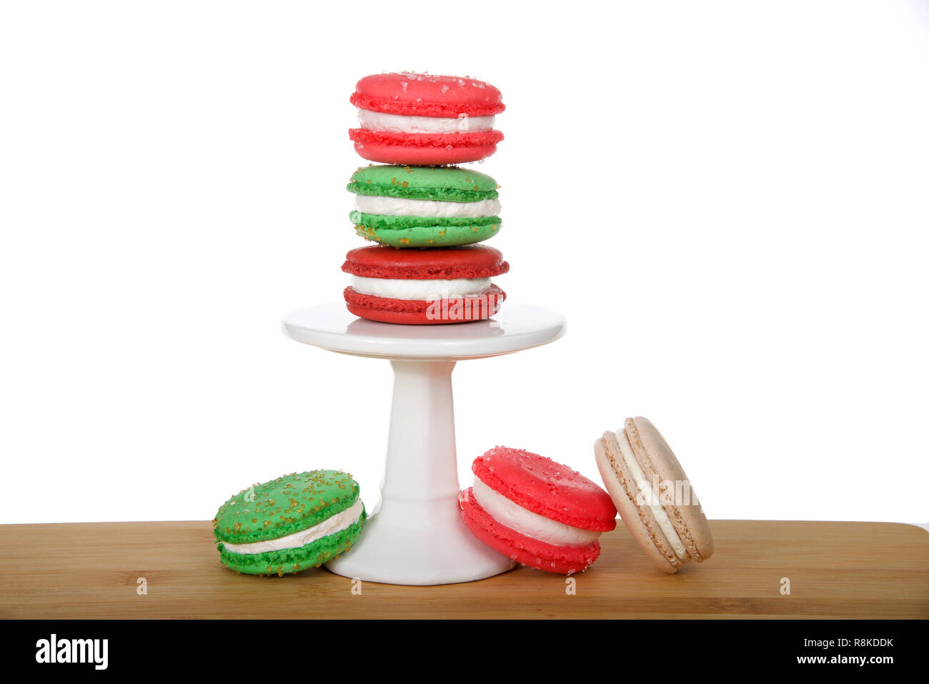 Vacanze di Natale style macaron cookies impilati su un piedistallo e posa sulla tavola di legno isolato su bianco. Design minimalista. Foto Stock