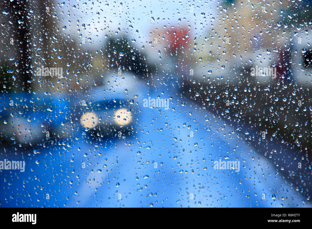 La pioggia sul vetro. La pioggia fuori dalla finestra sullo sfondo delle luci della citta'. Gocce di acqua caduta sul vetro durante la pioggia. Goccioline di acqua oltre il vetro del finestrino d Foto Stock