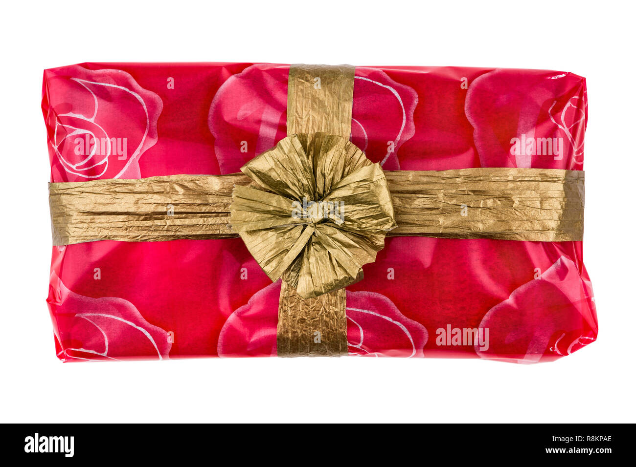 Confezione regalo avvolto in una rosa rossa cellophane, decorata con oro nastro di rafia e bow isolati su sfondo bianco Foto Stock