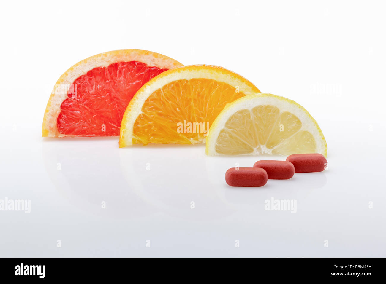 Pompelmo ,fette di arancia e limone con tre compresse di vitamina .vitamine naturali versus compresse sintetico Foto Stock