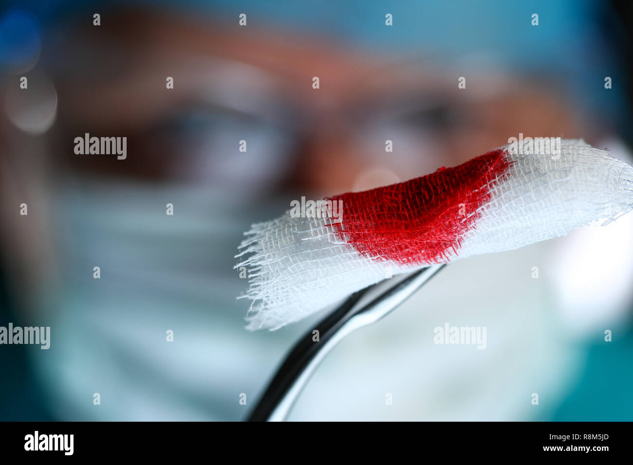 Medico chirurgo in sterili bracci uniforme tenendo gli utensili con materiale bio Foto Stock