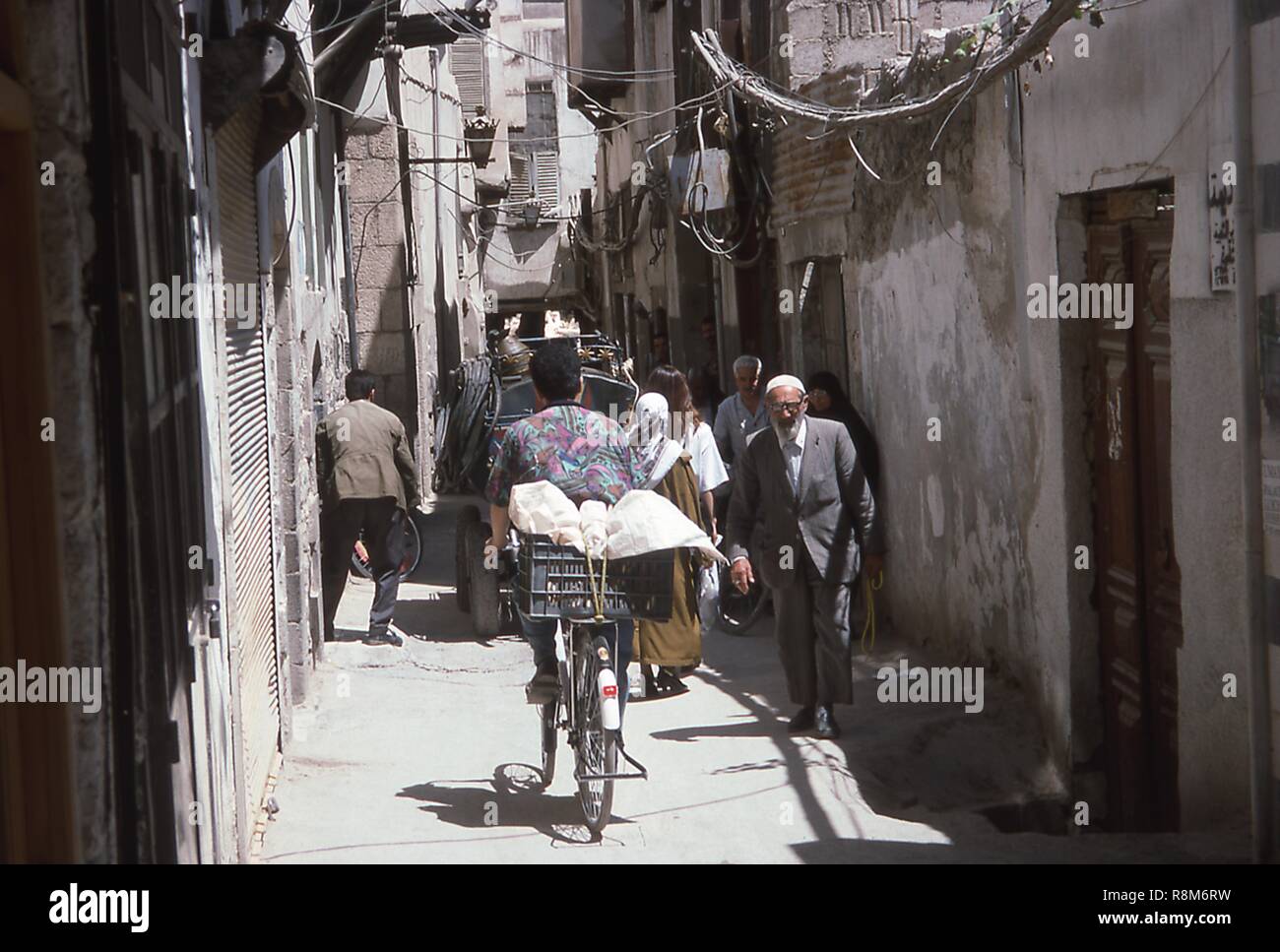 Scena di uno stretto vicolo affollato di pedoni e ciclisti in Damasco, Siria, Giugno 1994. () Foto Stock