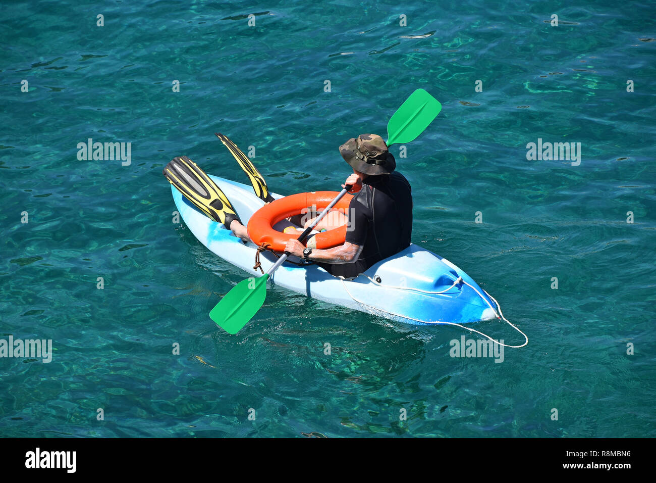 Angolo di alta vista di una spiaggia bagnino man a barca kayak in mare blu acqua Foto Stock