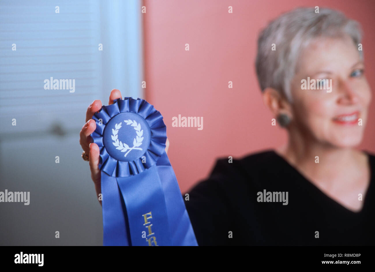 Donna matura che mostra il suo blue ribbon premio, STATI UNITI D'AMERICA Foto Stock