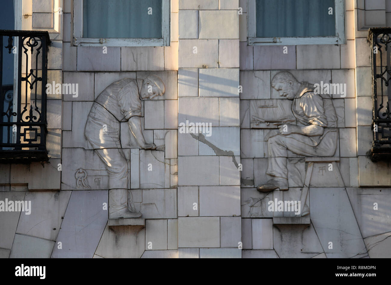 Un edificio bianco datato 1908 a Fitzalan quadrato che è decorato con raffigurazioni di metallo lavoratori in faience da Alfred e William Tory Foto Stock