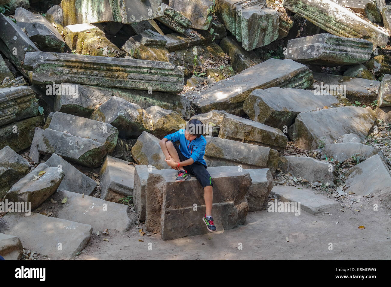 Turismo cerca ragazzo molto annoiato e stanco a un tempio in Cambogia, sud est asiatico Foto Stock