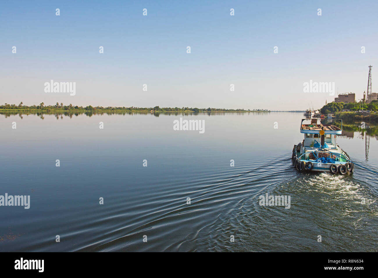 Piccolo rimorchiatore a traino yacht sul fiume Nilo in Egitto attraverso il paesaggio rurale paesaggio Foto Stock