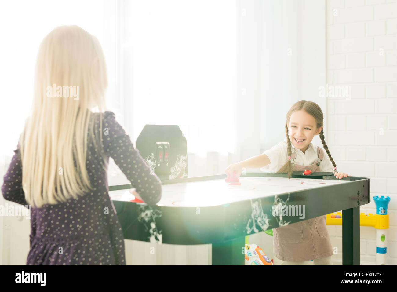 Ragazze eccitato giocare air hockey Foto Stock