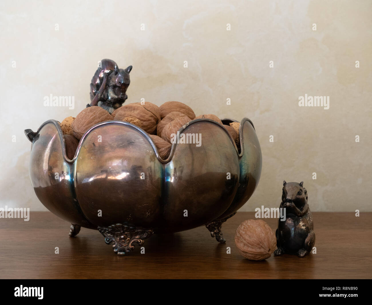 Opacizzato decorativo arco di argento con figurine di scoiattolo e miscelati i dadi nel guscio. Fotografato a livello degli occhi. Copia dello spazio. Foto Stock