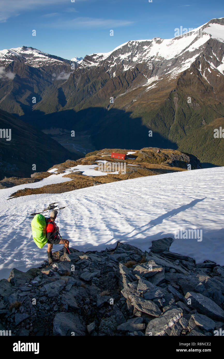 Escursionista nella neve sopra cresta francese capanna, Mt Aspiring National Park, Nuova Zelanda Foto Stock