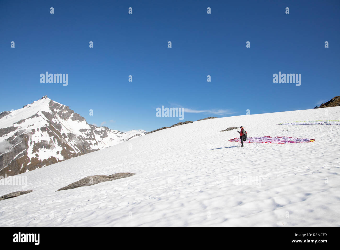 Lancio di parapendio off montagne innevate, Nuova Zelanda Foto Stock