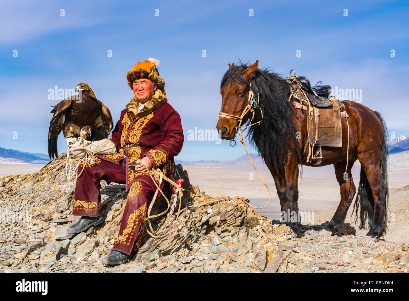 ULGII, MONGOLIA - Ottobre 9, 2018 : il mongolo Golden Eagle cacciatore con il suo cavallo e un ben addestrato golden eagle seduti sulla cima della montagna pronto Foto Stock