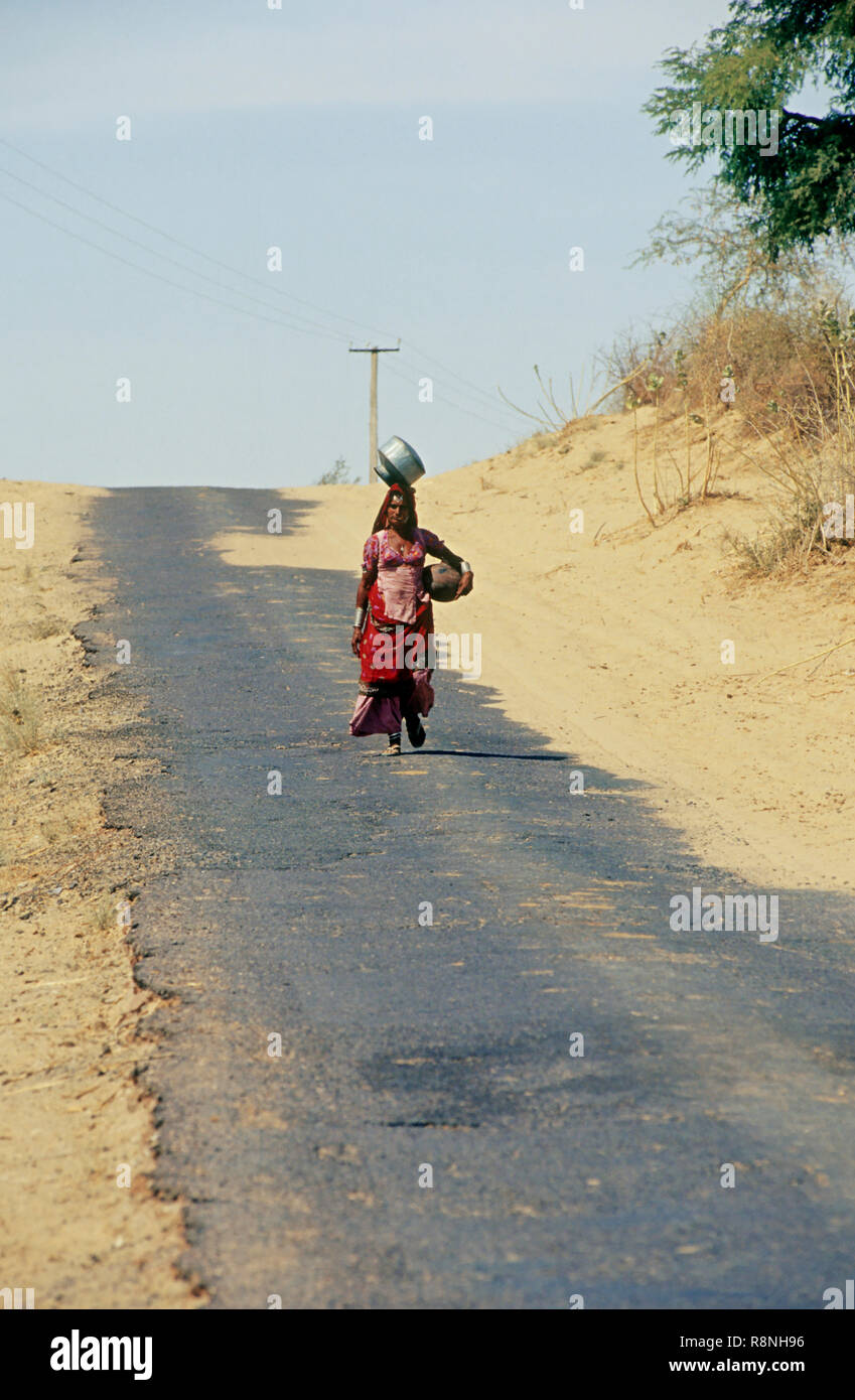 Donna che cammina per miglia ogni giorno per acqua, Rajasthan, India Foto Stock