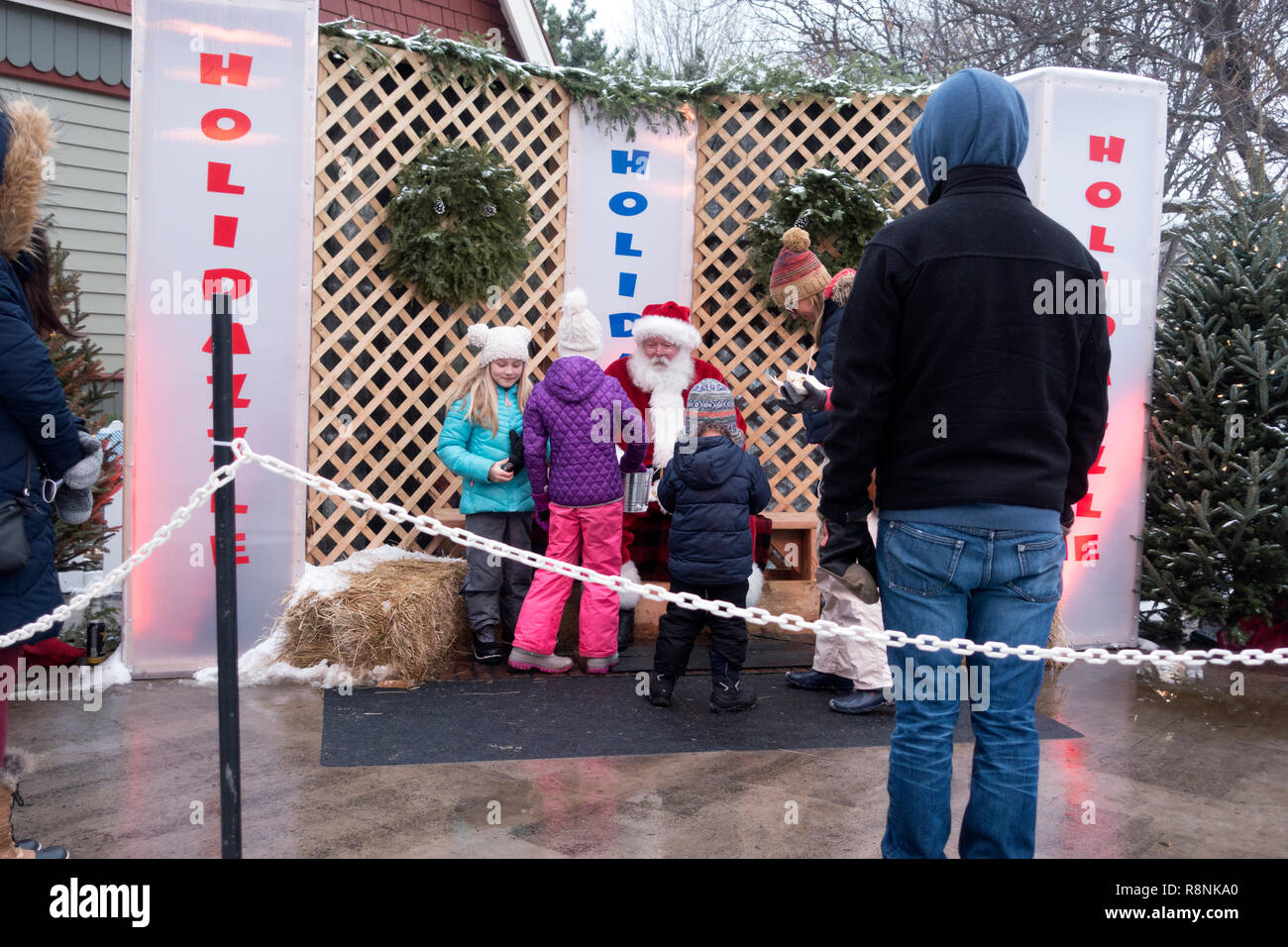 I ragazzi parlando di Babbo Natale con i genitori vicino all'inverno Holidazzle celebrazione presso Loring Park. Minneapolis Minnesota MN USA Foto Stock