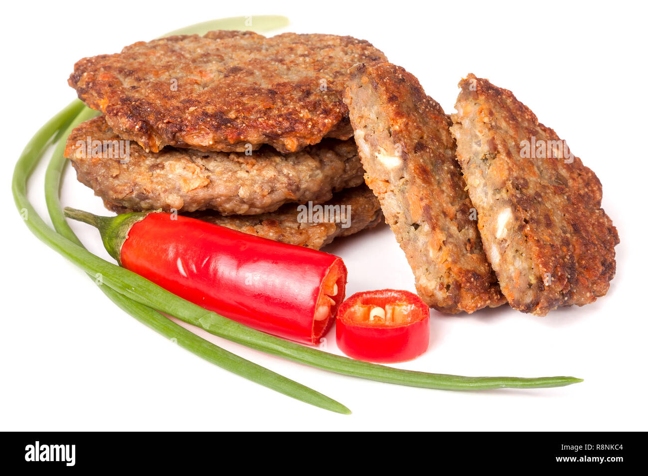 Frittelle di fegato o bistecche con peperoncino e cipolle verdi isolati su sfondo bianco Foto Stock