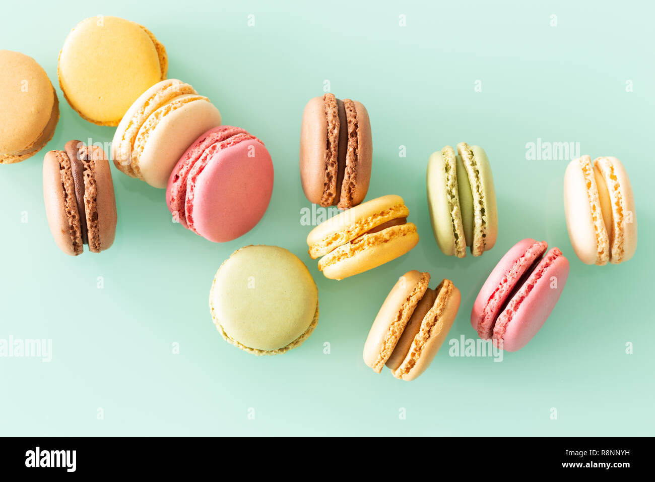Torta di amaretti in tenui colori sul verde pastello sullo sfondo di vetro Foto Stock