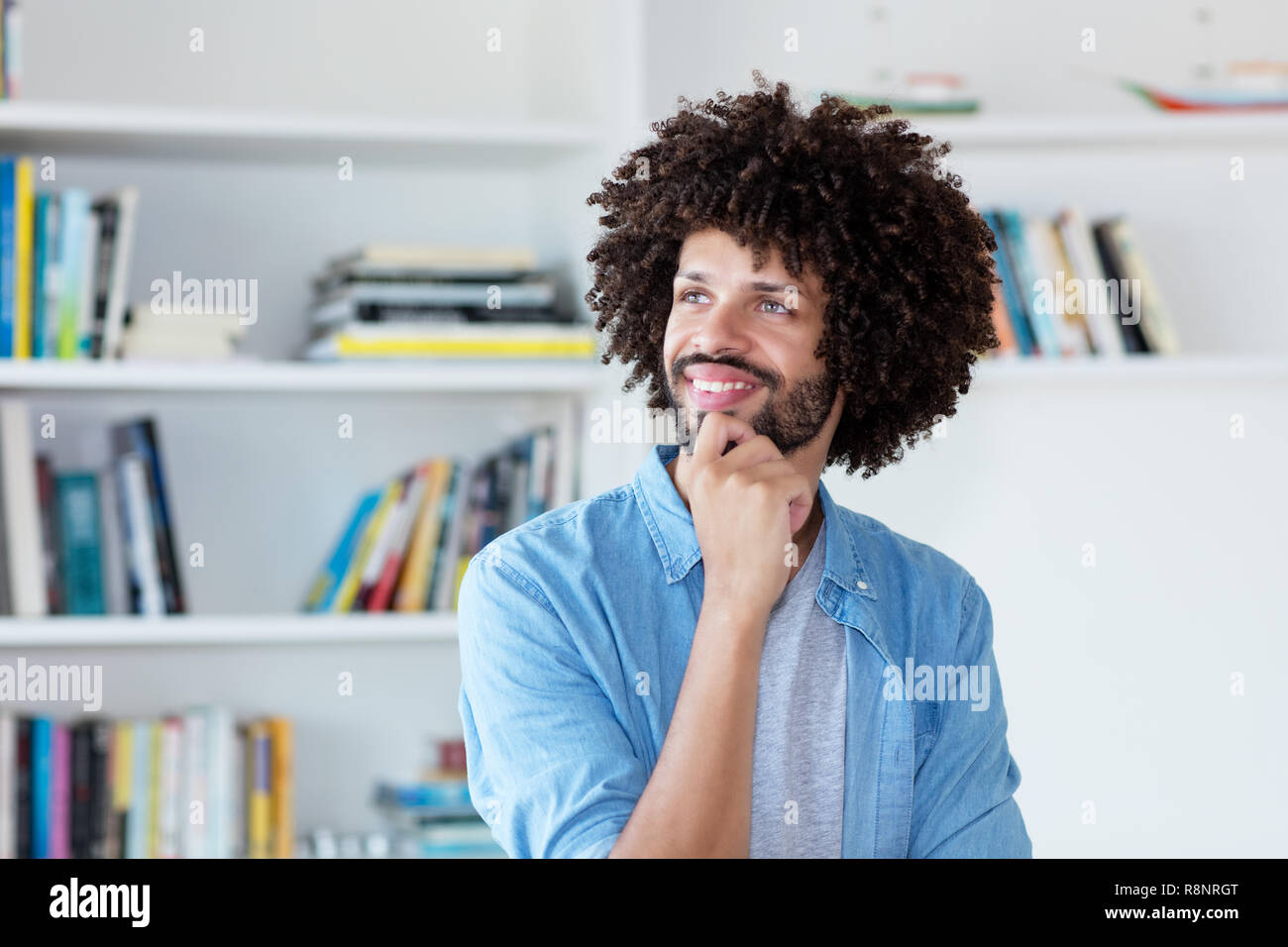 Pensando hipster uomo con capelli afro indoor a casa Foto Stock