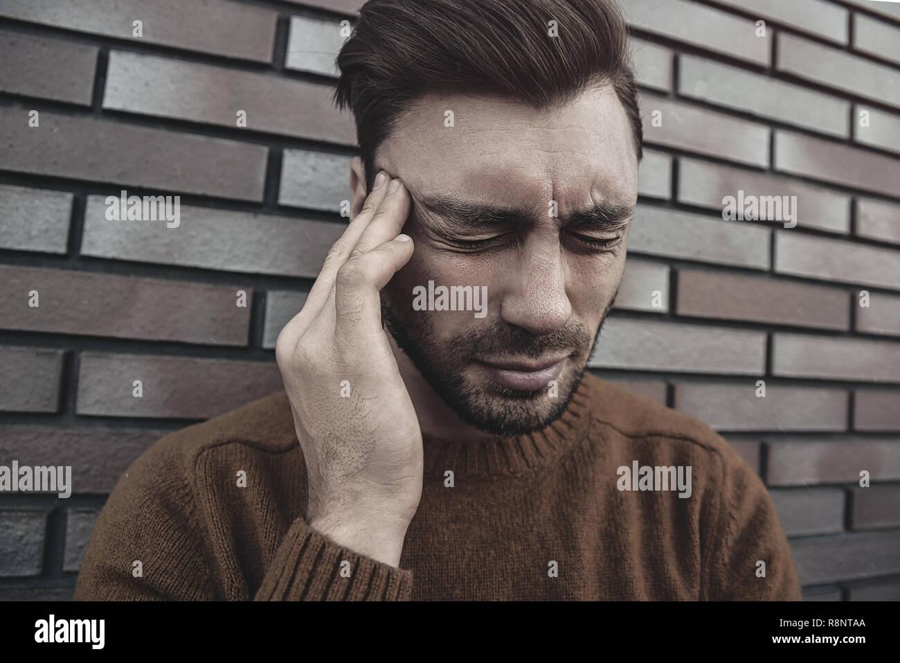 L'uomo sensazione emozioni dolorose, urlando, testimoniando la morte del caro amico, essendo miserabili e devastato, tenendo le palme sulla testa, urla di dolore un Foto Stock