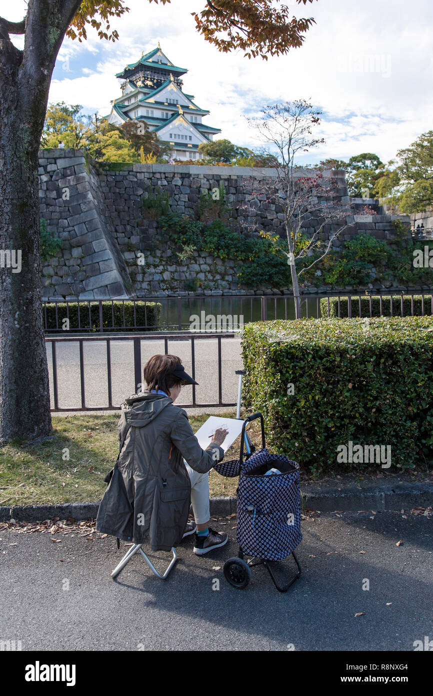Una donna anziana richiama il Castello di Osaka in Giappone Foto Stock