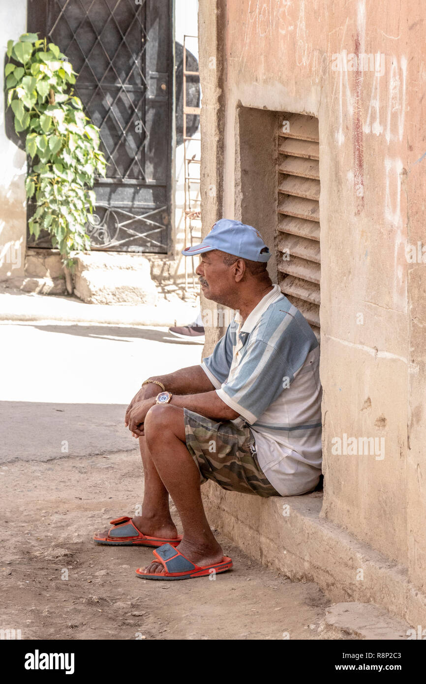 Il vecchio uomo cubano seduto sui gradini in ombra in Havana Cuba Foto Stock