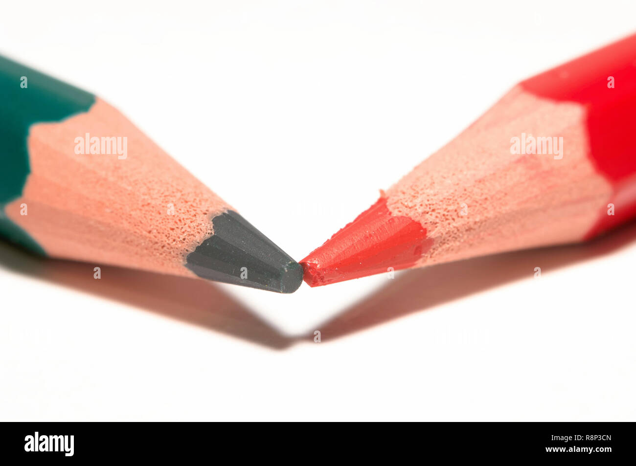 Macro di un verde e rosso e matita colorata, puntando insieme, isolato su carta bianca. Foto Stock