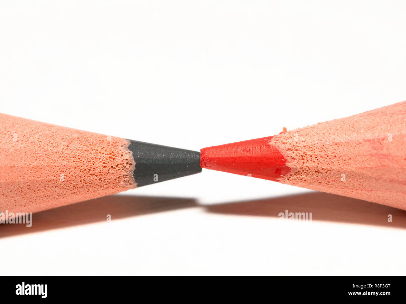 Macro di un verde e rosso e matita colorata, puntando insieme, isolato su carta bianca. Foto Stock