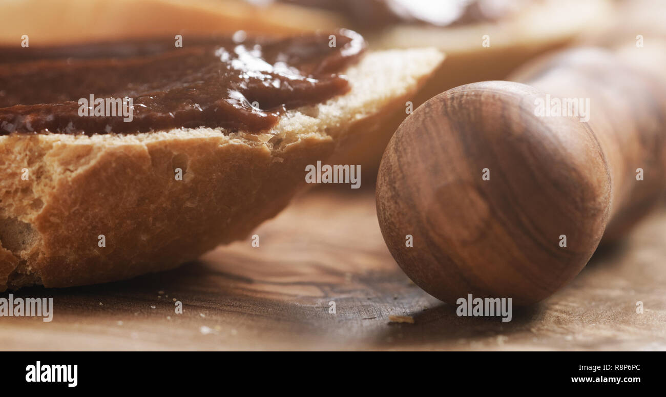 Primo piano della baguette fette con fatti in casa crema di nocciole gianduja sul bordo di taglio Foto Stock