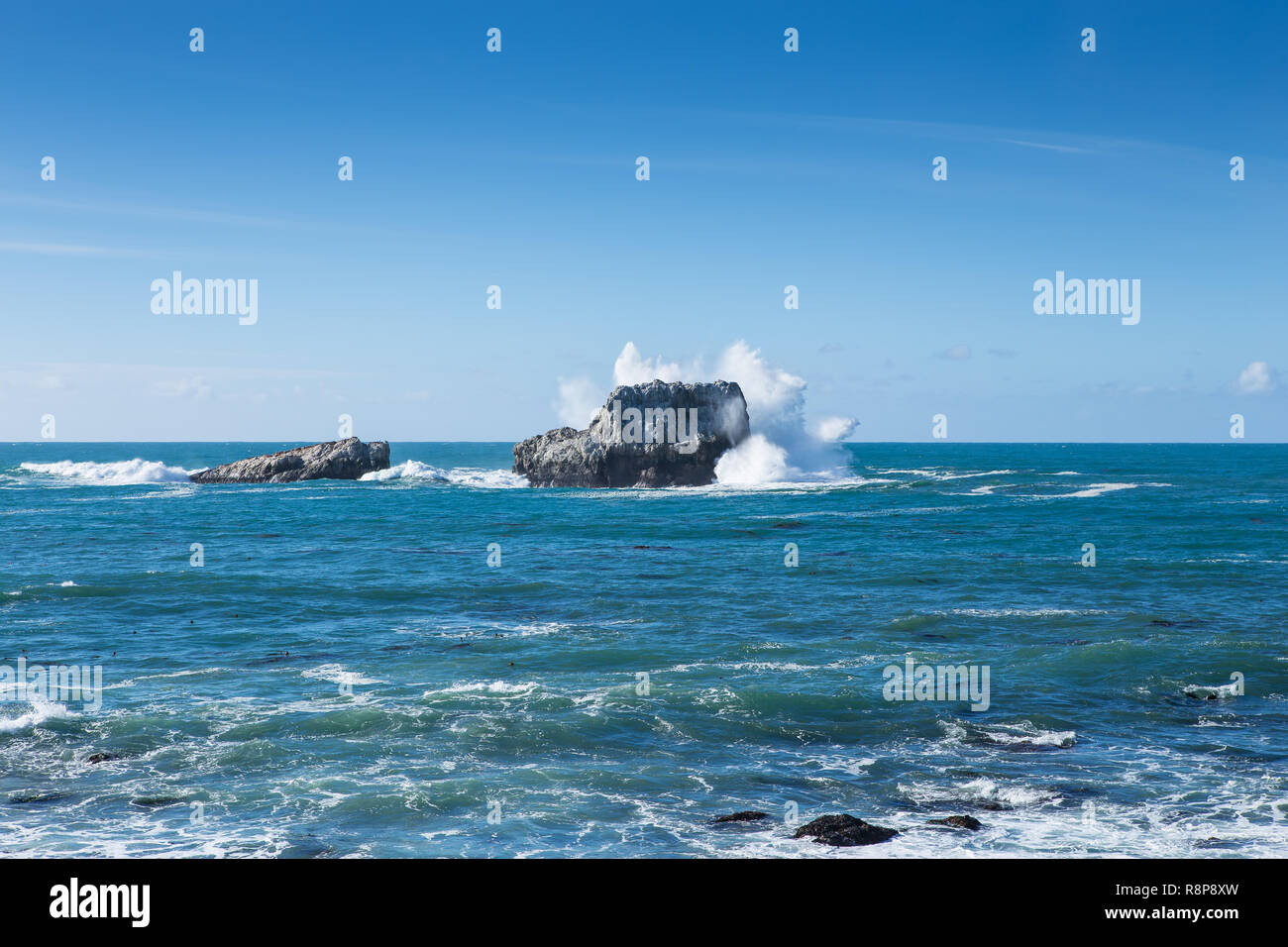 Onde che si infrangono e battenti spruzzare sulle rocce a PIEDRAS BLANCAS, San Simeone, CA, Stati Uniti d'America Foto Stock