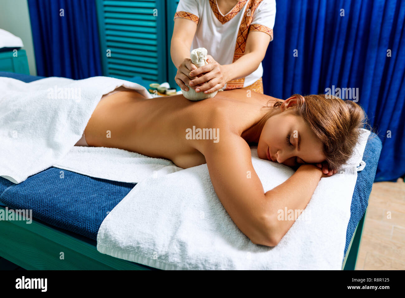Donna getting massaggio con erbe calde sacchetti. Foto Stock
