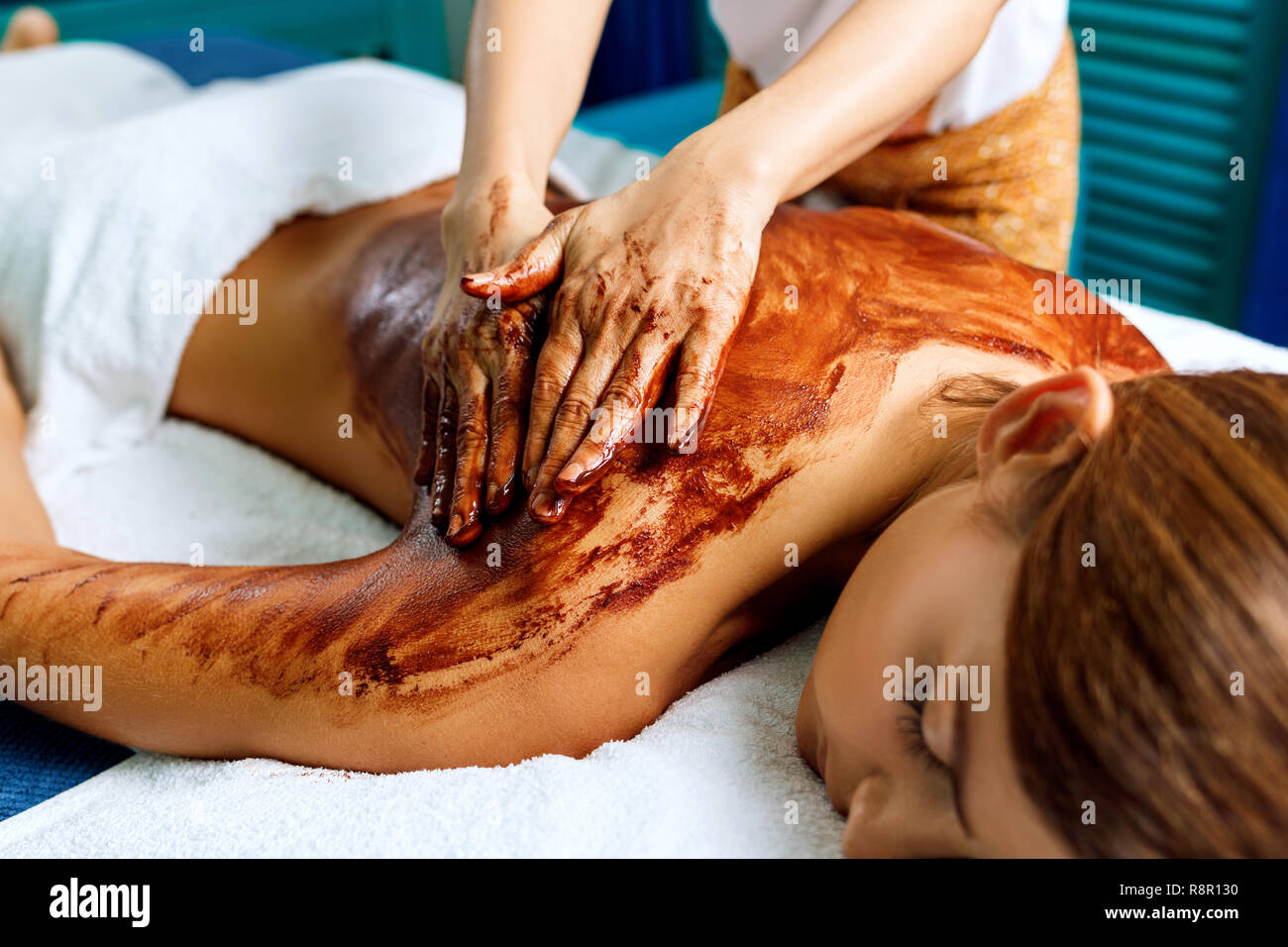 Massaggio della schiena con cioccolato maschera idratante. Foto Stock