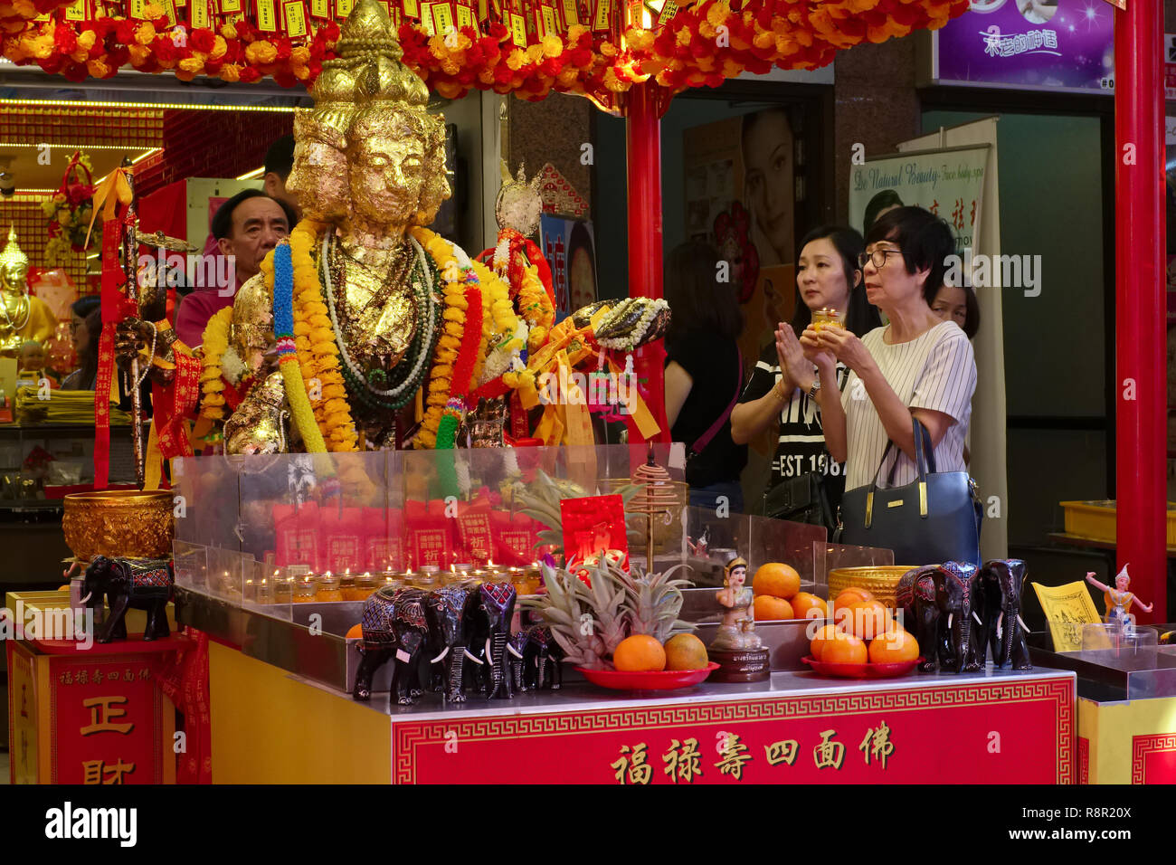 Adoratori presso un santuario dedicato a quattro-intitolata dio Brahma, l'Hindu Dio creatore, a Waterloo Street, l'area di Bugis, Singapore Foto Stock