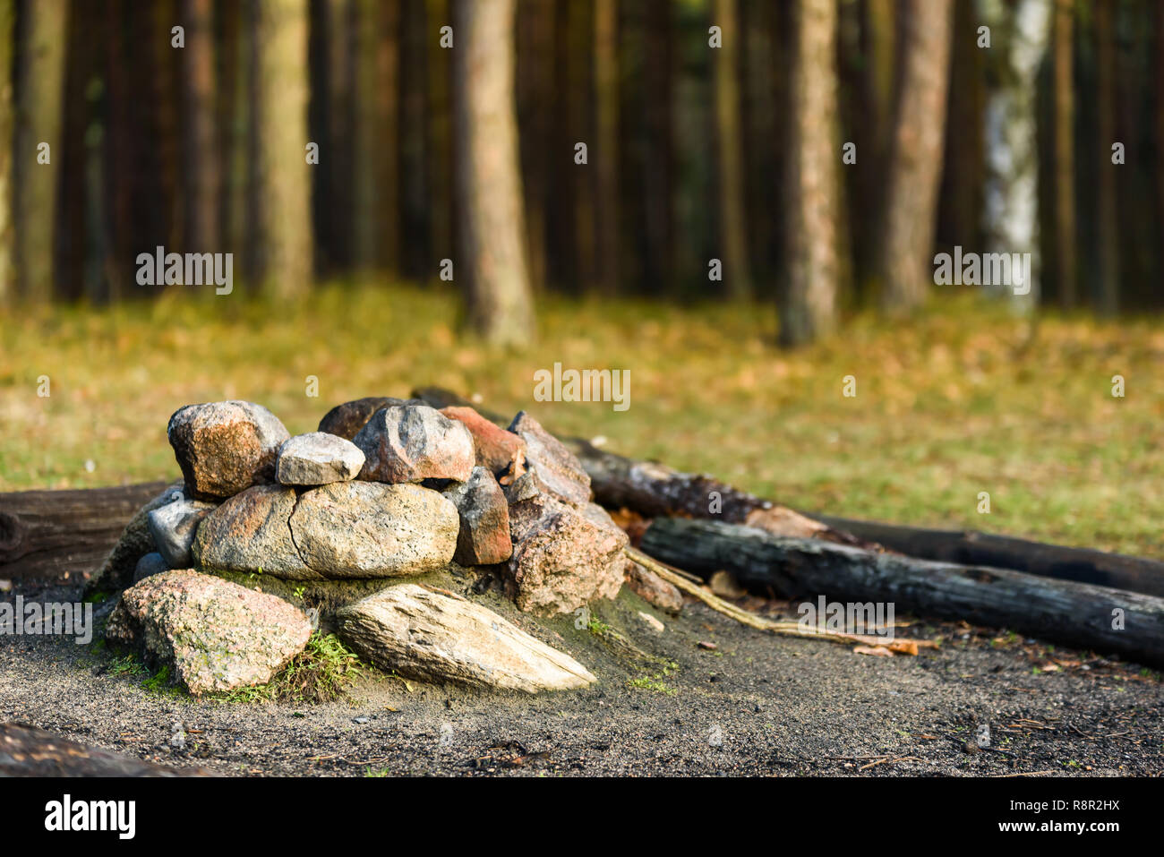 Tumulo di pietre formando un firepit nel paesaggio forestale. Foto Stock
