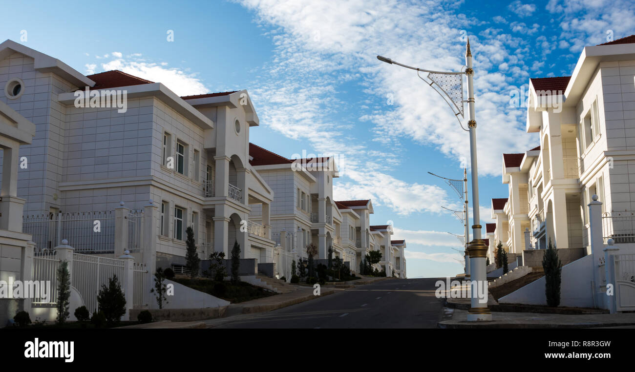 Quartiere residenziale di ville bianche con tetti rossi su uno sfondo di un blu cielo nuvoloso. Di immobili e proprietà Foto Stock