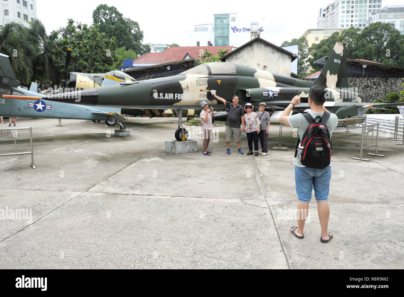 La città di Ho Chi Minh, Vietnam - Visitatori pongono accanto a un catturato American US Air Force F-5 jet da combattimento presso il Museo dei Resti della Guerra nel 2018 Foto Stock