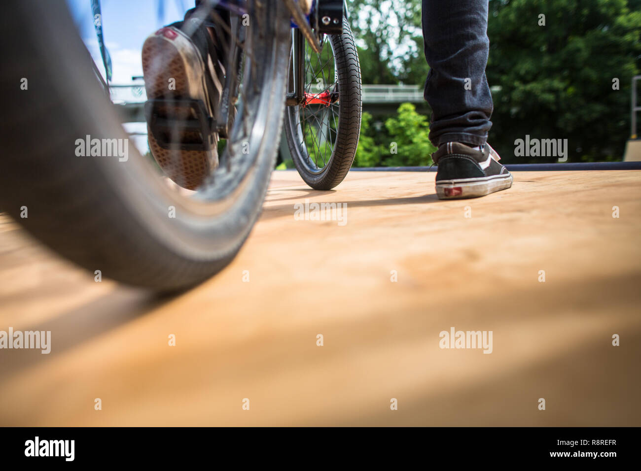 Giovane uomo con la sua bicicletta su una rampa, in procinto di fare alcuni trucchi insano. Concetto di BMX. Foto Stock