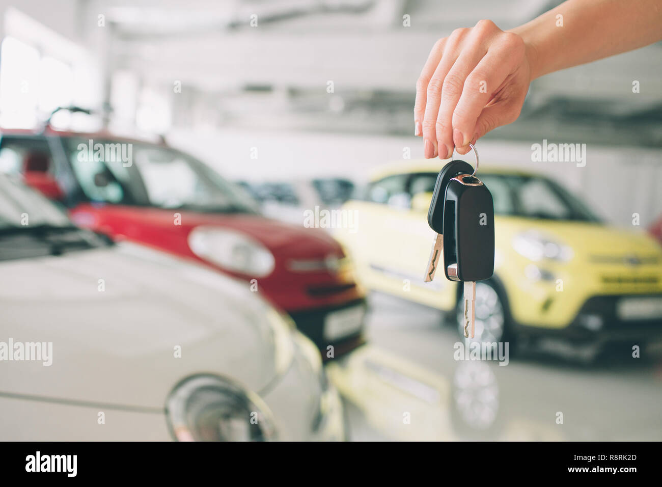 Passando le chiavi dell'auto. Ritagliato closeup di una concessionaria auto tenendo fuori le chiavi dell'auto alla telecamera copyspace concessionaria auto salon manager venditore acquisto vendita dando proprietario professione acquisto concetto del veicolo Foto Stock