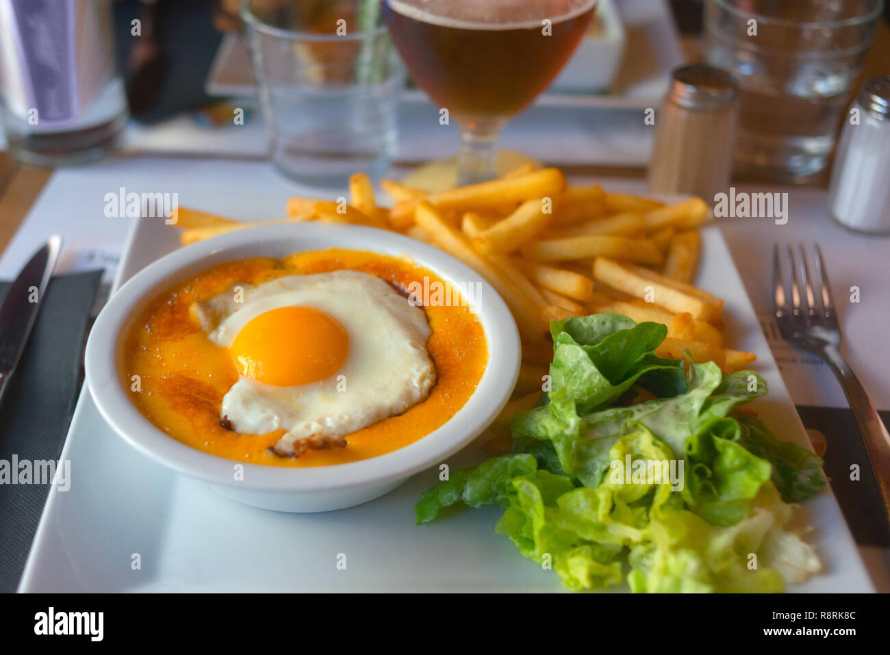 Francia settentrionale specialità locale piatto, il Welsh rarebit con prosciutto, uova e fuso il formaggio cheddar, spesso servito con la birra. Foto Stock