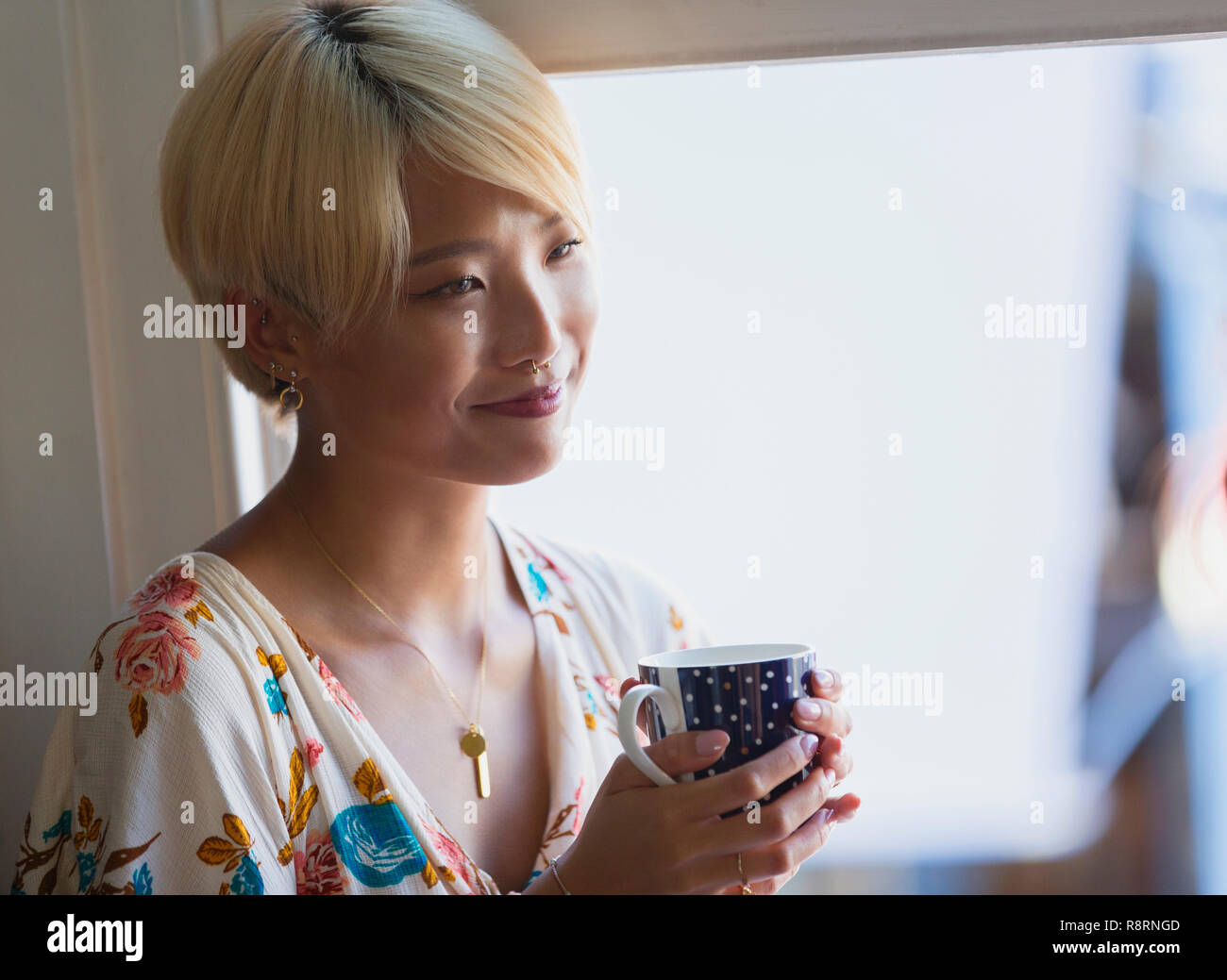 Sorridente giovane donna di bere il caffè Foto Stock