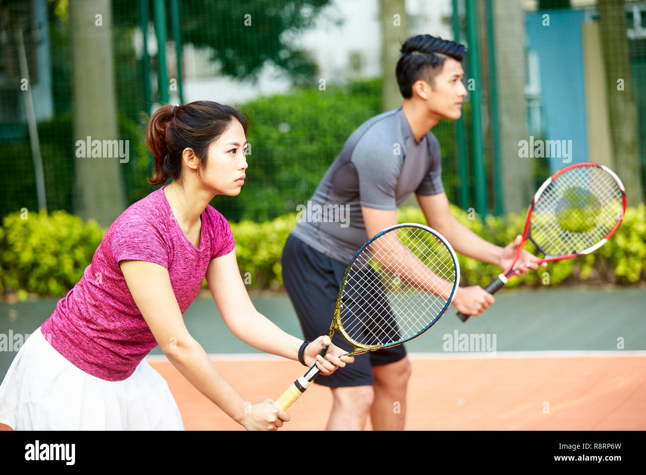 Giovane coppia asiatica di un uomo e di una donna in un doppio misto corrispondono, concentrarsi sulla donna in primo piano Foto Stock