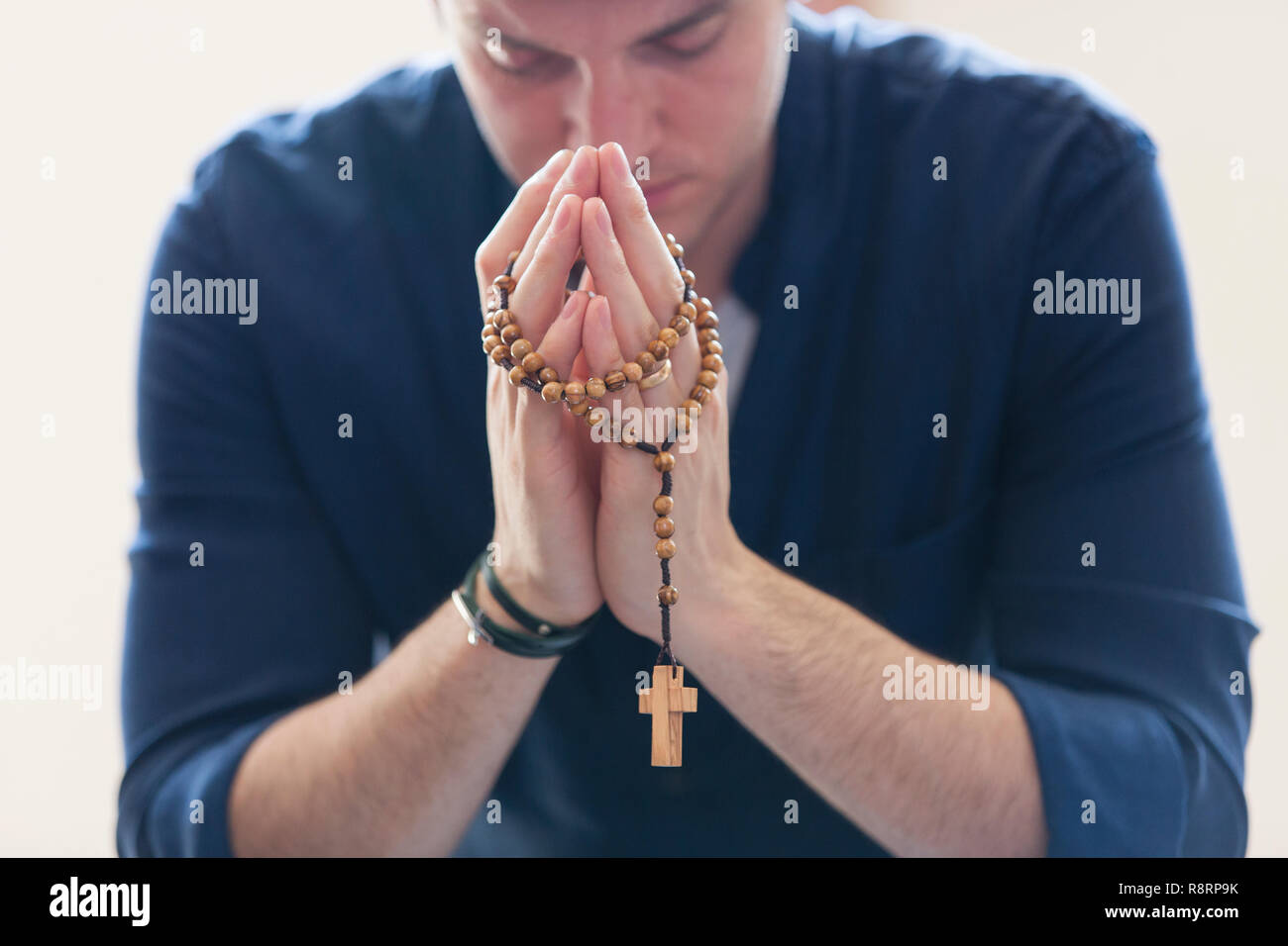 Serena uomo che prega con il rosario Foto Stock