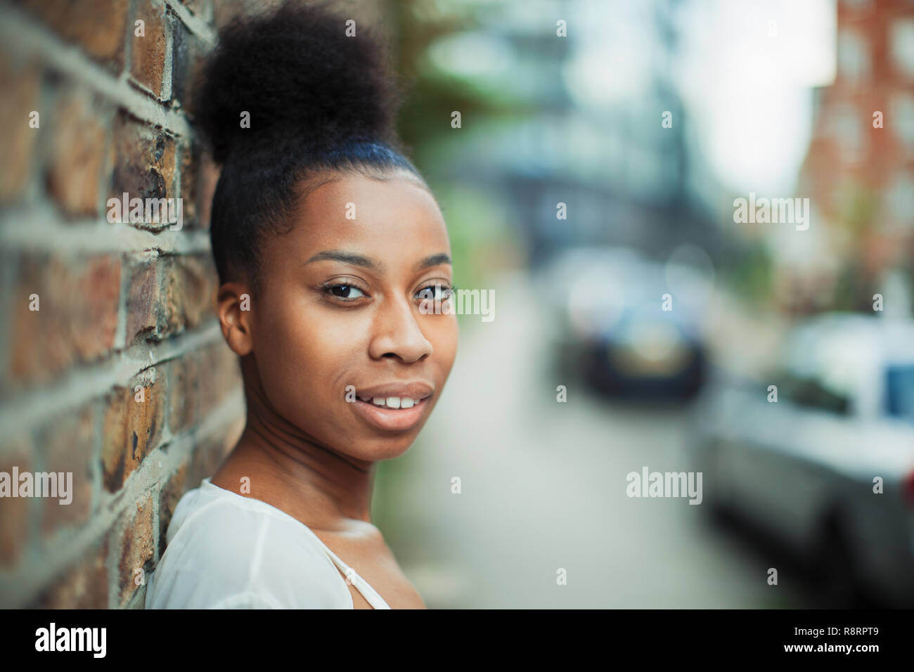 Ritratto fiducioso giovane donna sul marciapiede urbano Foto Stock