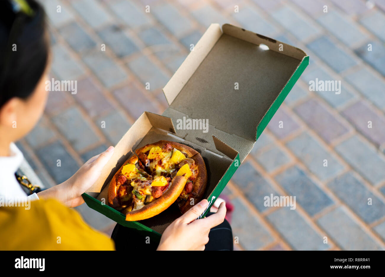 Donna avente una pizza all'aperto vista superiore Foto Stock