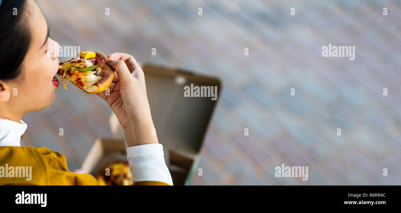 Donna avente una pizza all'aperto vista superiore Foto Stock