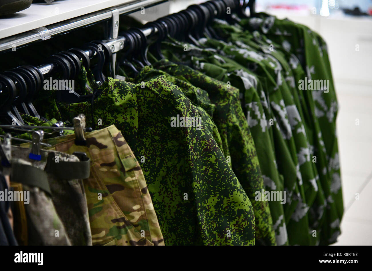 Abbigliamento camouflage su appendiabiti in negozio Foto Stock